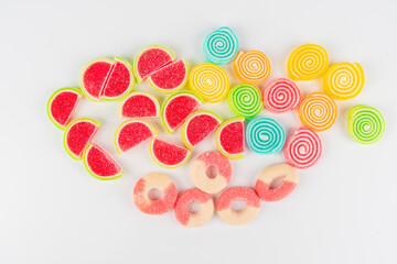 Fototapeta premium Swedish candies in a assorted piles with hearts, carrots, fruit rings, and licorice on white background. 