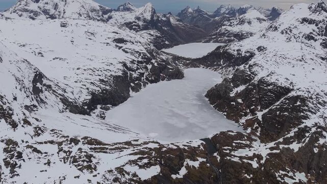 Exploring a large frozen lake surrounded by mountains in a snowy landscape