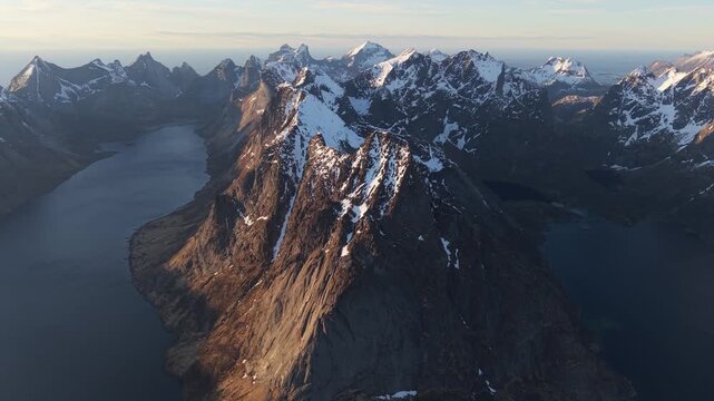 Snowy mountains and lakes view in Norway during golden hour near sunset