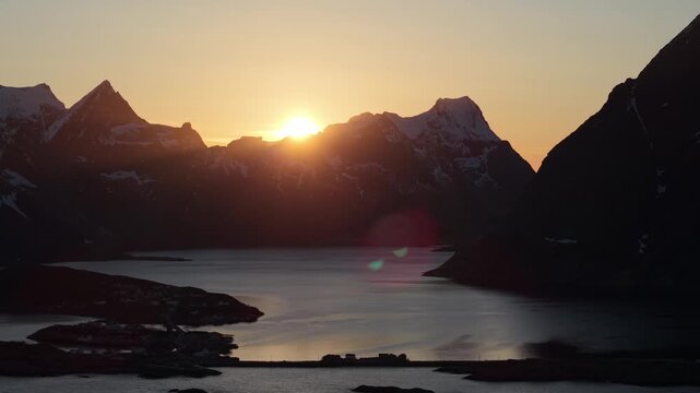 Sunrise over mountains and water in a quiet location with clear skies