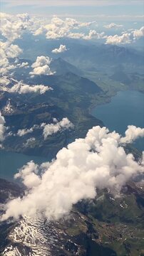 Alps mountain range in Europe seen from above with expansive white clouds rugged peaks and blue sky travel nature background banner poster print design