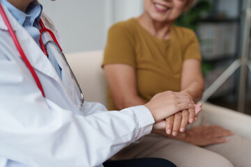 Obraz premium Medical doctor provides comforting support by holding a senior woman's hand, demonstrating empathy and trust during a healthcare appointment or wellness check