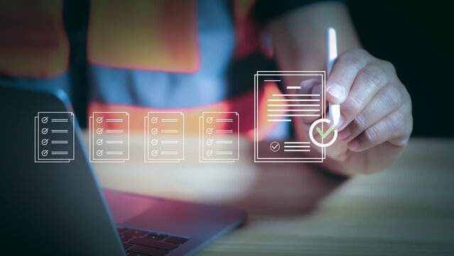 Engineer using stylus pen signing digital document for online approval and safety inspection checklist. Quality control management, compliance, and smart construction technology concept.