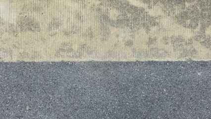 Fototapeta premium Asphalt and concrete road surface texture. Texture background of asphalt and concrete junction. High angle shot of split concrete surface texture. Two-tone concrete texture.