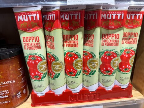 Santa Ponca, Spain - May 05, 2026: Mutti doppio concentrato di pomodoro tomato paste tubes displayed on a shelf in a grocery store with a jar of sauce nearby