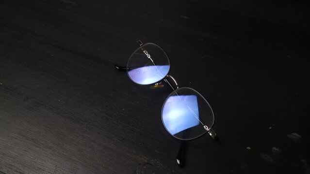 Elegant Round Metal Eyeglasses with Blue Light Coating on a Dark Textured Background