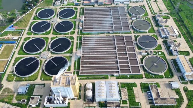 Aerial view of a large sewage treatment plant with circular clarifiers and rectangular aeration tanks under bright daylight in Dhaka, Dhaka Division, Bangladesh.