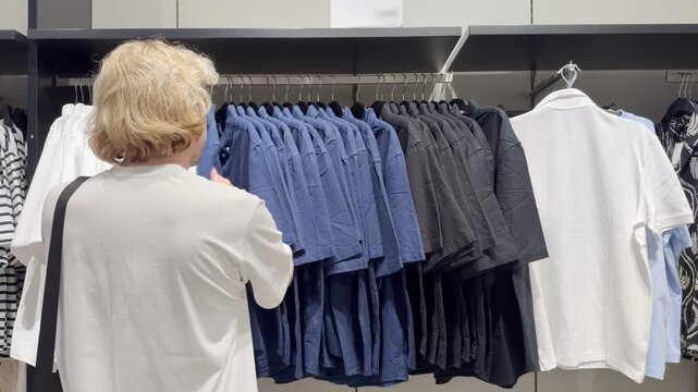 Clothes store in shopping mall.Blurred store aisle with hanging clothing racks