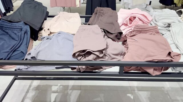 Clothes store in shopping mall.Blurred store aisle with hanging clothing racks