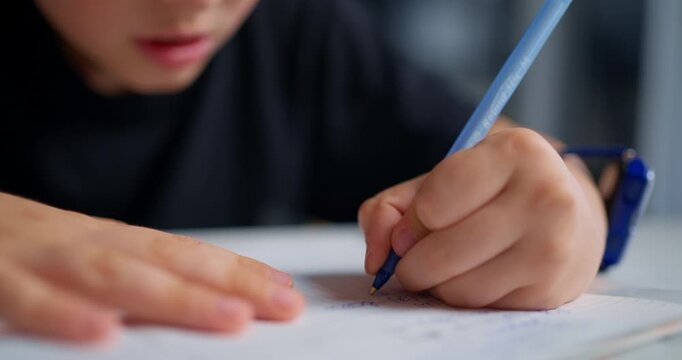 Young Student Concentrating Intensely On Homework While Using Smartwatch In Evening Kitchen
