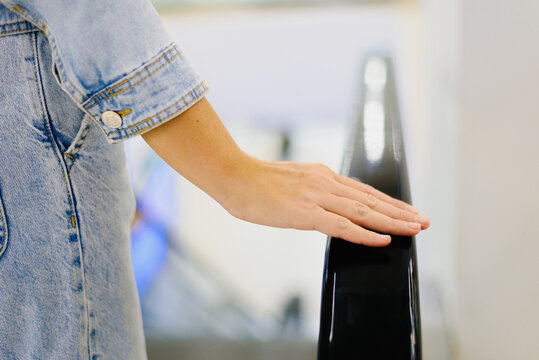 Customer Hand on Escalator Railing in Mall