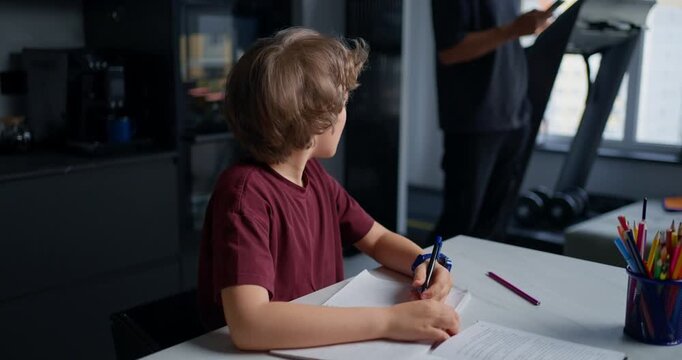 Young Male Diligently Completing Homework Assignment. Child Engaged In Studying With Positive Attitude