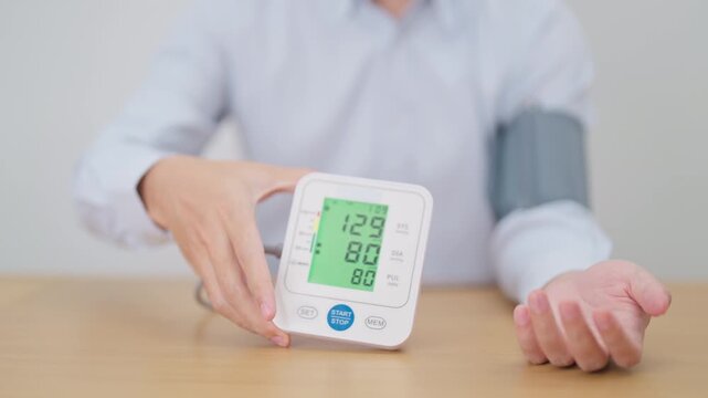 Man checking Blood pressure by Blood pressure monitor with Cuff. Systolic, SYS, Diastolic, DIA, Pulse, Hypertension, Hypotension, Heart rate, Cardiovascular Disease and May World hypertension day