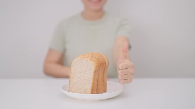 Happy smiling woman with whole wheat bread and thumbs up gesture. Weight loss, Dieting, Healthy eating, Calorie control, Fitness food, High fiber, Wellness, Lifestyle, Metabolism and Glycemic Index