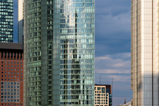 Cloudy sky presses over glass towers and facades in Frankfurt Germany, tightening the financial district skyline into layered urban architecture