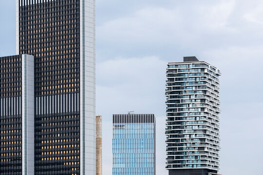 Cloudy light softens the Frankfurt Germany skyline as highrise towers and a residential building define urban financial district architecture