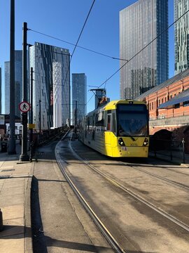 Manchester, England, UK - February 22, 2026: Manchester Metrolink tram traveling along Lower Mosley Street with modern city skyline in the background.