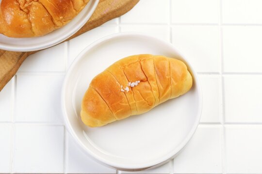 Popular salt bread known as shio pan in Japan and sogeum ppang in Korea, featuring a golden crispy crust and soft fluffy inside, ideal for bakery and breakfast themes.