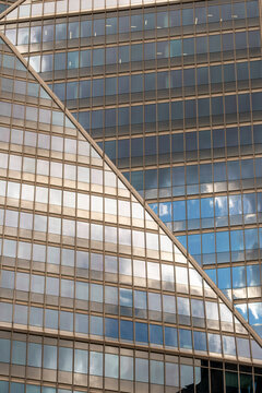 Curved reflections sweep across a glass facade where office buildings and windows shape corporate architecture patterns in an abstract view