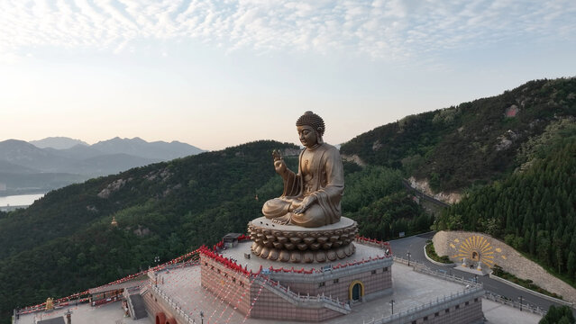 Shandong Nanshan Giant Buddha at dawn with mountain landscape captured by aerial photography