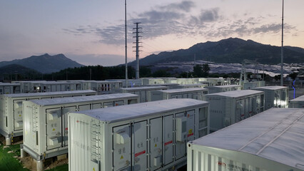 Fototapeta na wymiar Energy storage power station with container arrays in mountainous area during twilight