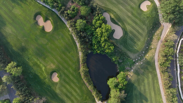 Aerial view of a golf course featuring sand traps, water hazards, and meticulously maintained green fairways