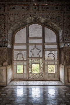 Beautiful window design at Fort of Lahore showcasing intricate lattice work and stone flooring in Lahore, Pakistan