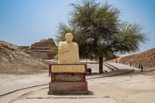 Visitors observe the ancient statue at the UNESCO site of Moenjodaro in Pakistan while learning about its history and significance