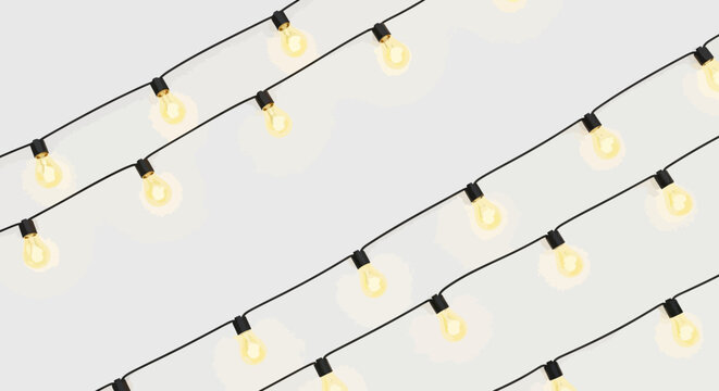 String lights with glowing bulbs against a white wall festive illumination