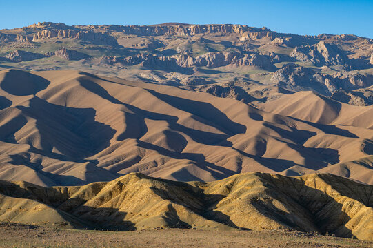 Overlook view of rocky hills and mountains in Bamyian, Afghanistan, showing various land formations and sunlight shadows