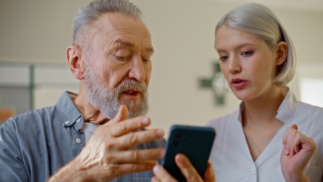 Pharmacist patient reviewing smartphone at drugstore closeup. Skilled physician