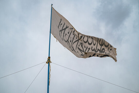 Flag of the Taliban displayed against the sky in Afghanistan, reflecting the presence of the group in Ghazni region