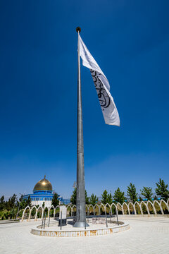 Giant flag of the Islamic Emirate waving on Wazir Mohammad Akbar Khan hill in Kabul, Afghanistan under a clear sky