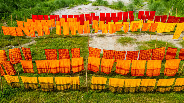 Freshly dyed cloths hanging in Araihazar village, showcasing traditional dyeing practices and vibrant colors