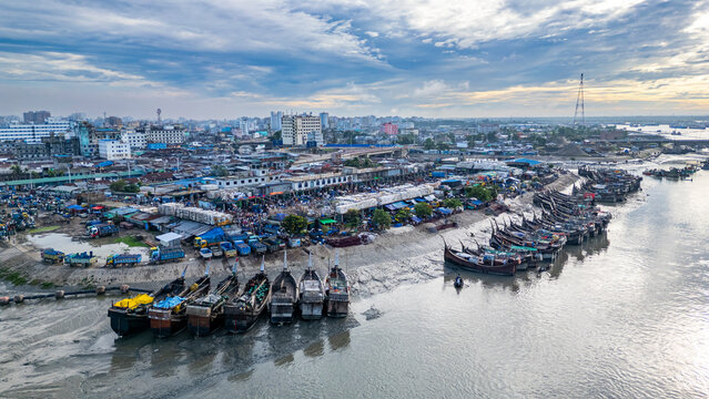 View of fish market with boats along the river in Chittagong, Bangladesh during a cloudy day
