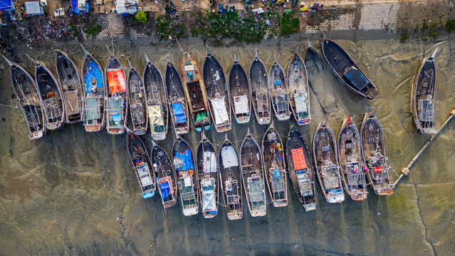 Market activity at Fish market in Chittagong with boats lined up and people engaged in trade