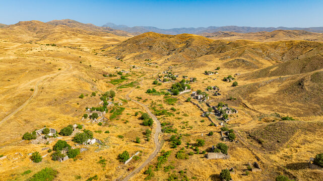 Aerial view of a destroyed village in Qarabaqh with remnants of buildings and nature recovery in Azerbaijan