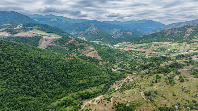 Aerial view showcases a vast canyon surrounded by hills in a rural area of Azerbaijan during overcast weather