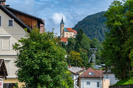 Tourists explore the historic mercury mine of Idrija while admiring surrounding landscapes in Slovenia on a clear day