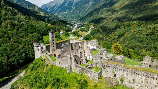 Aerial view shows Mesocco castle ruins surrounded by mountains and greenery in Switzerland