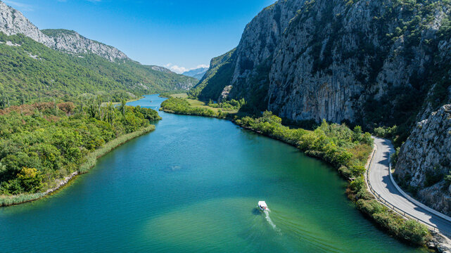 View of the Cetina gorge and river with boat navigating through water in Croatia