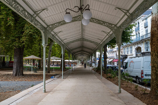 Visitors walking through a covered promenade in the spa town of Vichy, France while enjoying the local atmosphere