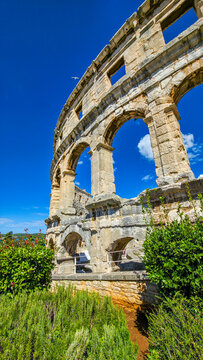 Roman amphitheatre in Pula showcases ancient architecture in blue sky