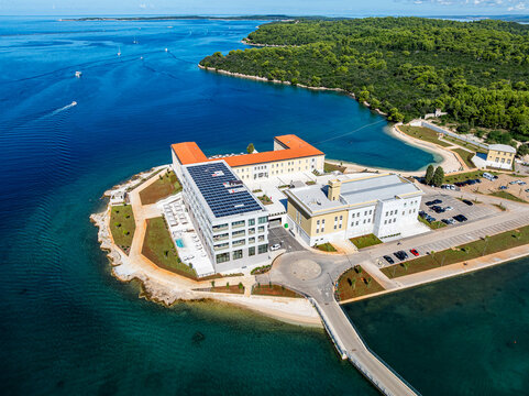 Luxury resort overlooks water on peninsula in Pula, Istria, Croatia, with boats in the background
