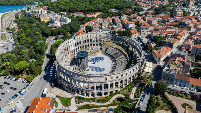 View of the Roman amphitheatre in Pula, Istria, Croatia surrounded by urban landscape and green trees