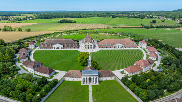 Exploring the Royal Saltworks at Arc-et-Senans, France from above in a clear daytime sky