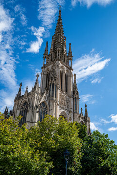Basilica Saint-Epvre rises above trees under a clear blue sky in Nancy, France