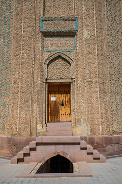 Momine Khatun Mausoleum shows intricate stonework and a wooden door in Nakhchivan, Azerbaijan during daylight hours