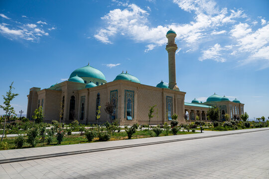 Haydar Mosque stands in Nakhchivan showcasing its design with blue domes and tall minaret during a sunny day in Azerbaijan