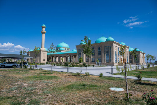 Visitors admire the unique architecture of Haydar Mosque with turquoise domes and tall minarets under a clear blue sky in Nakhchivan, Azerbaijan
